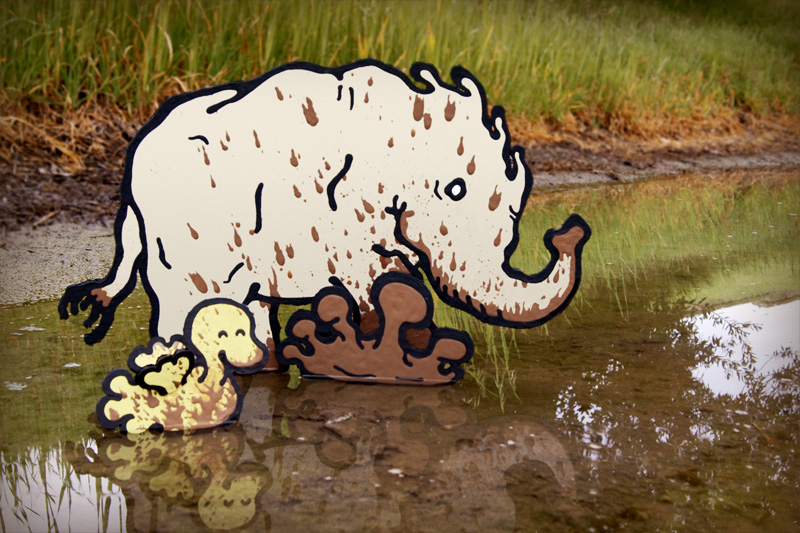 cardboard elephant and carboard bird enjoying splashing in the mud